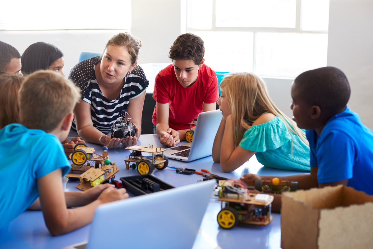 An instructor guiding students through a hands-on project at Hexagon Academy